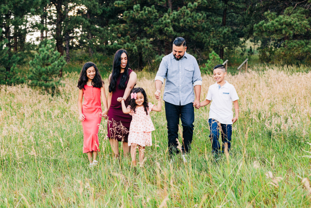 Family walking through Evergreen Colorado together for a family photo