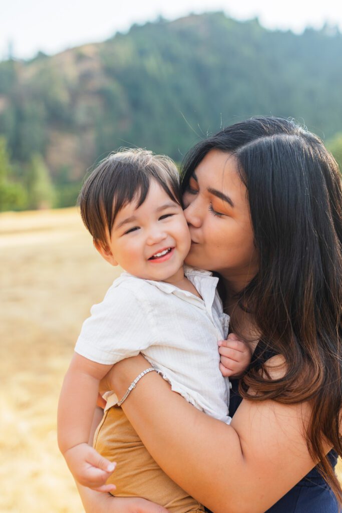mom kissing little boy during photos at Whistler's Bend Park