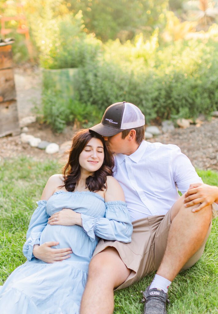 couple snuggling together excited about their pregnancy and posing for photos