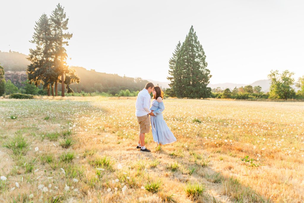 couple posing close together for pregnancy photos in Roseburg