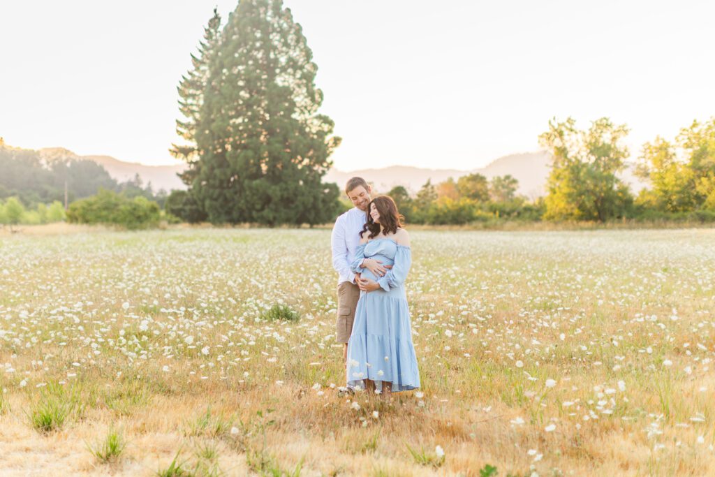 couple posing in oregon field for maternity photos