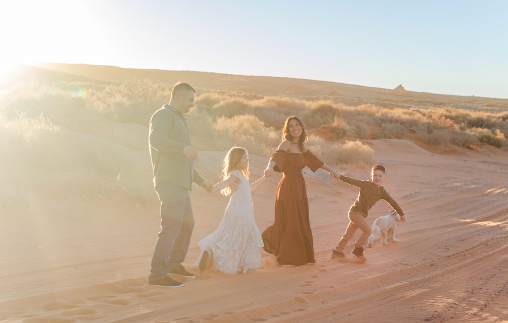 family walking in a line and playing during their St. George family photos at Sand Hollow state park